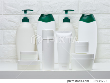 White plastic jars and tubes for liquid cosmetics on a white background 96934725