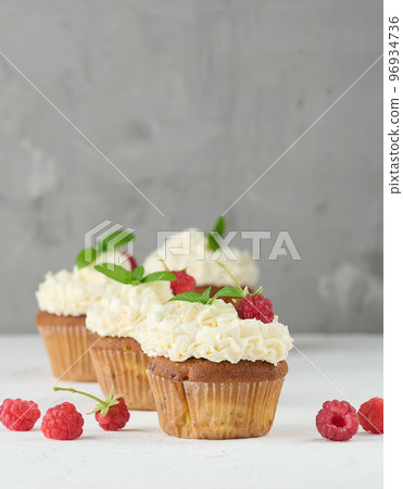 Baked cupcakes with white butter cream on the table, delicious dessert Baked cupcakes with white butter cream on the table, delicious dessert 96934736