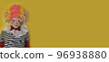 A boy in a clown costume on the background of a bright yellow wall is fooling around and smiling 96938880