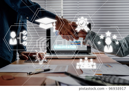 Qualification concept, business partnership handshaking after perfect deal with qualification icon on virtual screen. 96938917