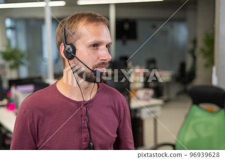 Caucasian bearded man with a headset. Male call center worker Caucasian bearded man with a headset. Male call center worker 96939628