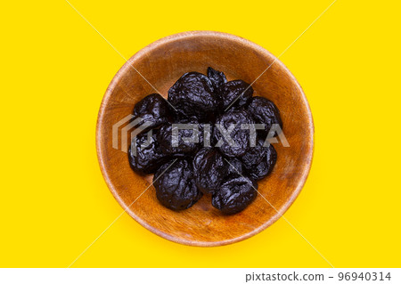 Dried prunes on yellow background Dried prunes on yellow background 96940314