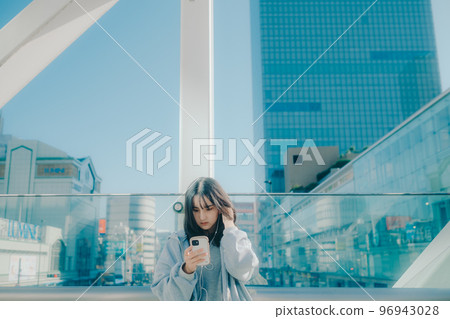 Photo with a high school girl and a smartphone in the city 96943028