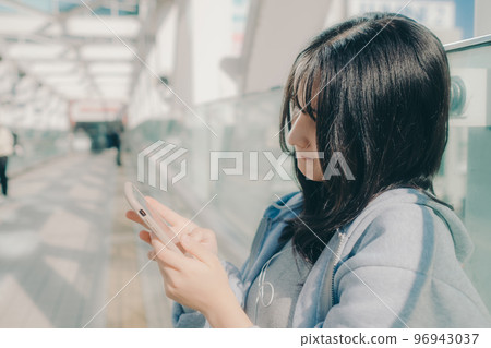 Photo with a high school girl and a smartphone in the city 96943037