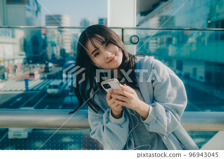 Photo with a high school girl and a smartphone in the city 96943045