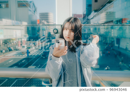 Photo with a high school girl and a smartphone in the city 96943046