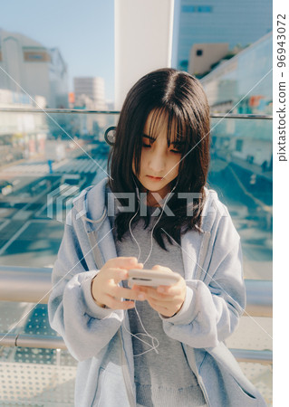Photo with a high school girl and a smartphone in the city 96943072
