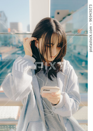 Photo with a high school girl and a smartphone in the city 96943073