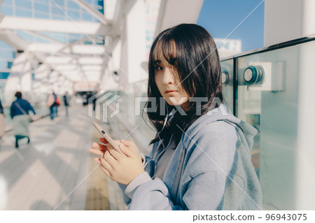 Photo with a high school girl and a smartphone in the city 96943075