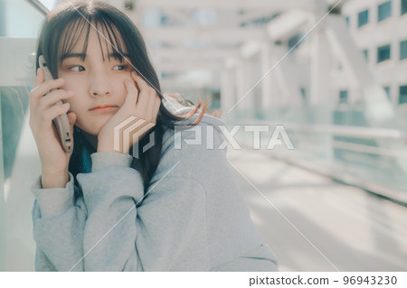 Photo with a high school girl and a smartphone in the city 96943230