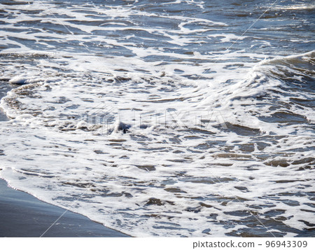 White waves on the beach. 96943309