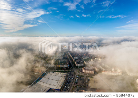 Top aerial view of fluffy white clouds over modern city with high rise buildings. 96944072