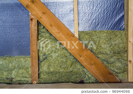Thermal insulation mineral rock wool installation at the new building attic wall 96944098