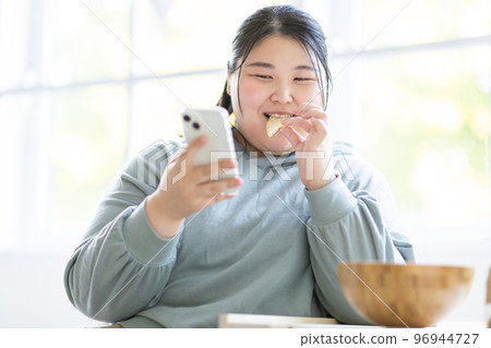 A woman watching a smartphone 96944727