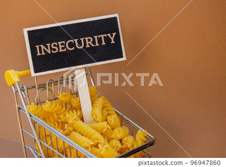 INSECURITY text on Blackboard label against Shopping trolley cart Filled With Pasta on Beige background. Food and groceries shopping price increase, Rising food cost food crisis inflation INSECURITY text on Blackboard label against Shopping trolley cart Filled With Pasta on Beige background. Food and groceries shopping price increase, Rising food cost food crisis inflation 96947860