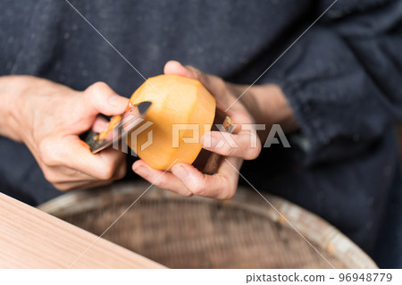老婦人用菜刀剝澀柿子 96948779