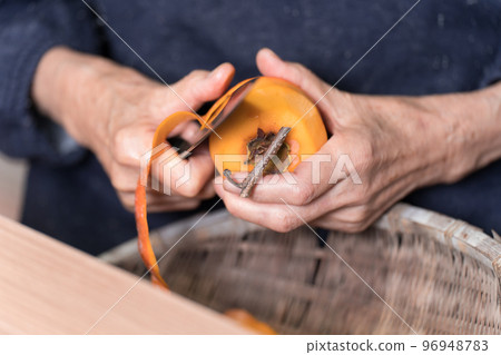 老婦人用菜刀剝澀柿子 老婦人用菜刀剝澀柿子 96948783