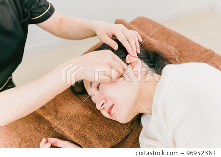 A woman and a therapist ear esthetician undergoing treatment at an ear cleaning salon, ear esthetic, otolaryngology A woman and a therapist ear esthetician undergoing treatment at an ear cleaning salon, ear esthetic, otolaryngology 96952361