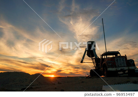 Coober Pedy sunset and truck silhouette Coober Pedy sunset and truck silhouette 96953497