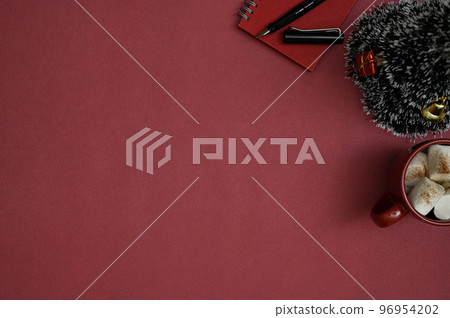 Top view, Red workspace in Christmas theme with copy space, small Christmas tree, hot chocolate Top view, Red workspace in Christmas theme with copy space, small Christmas tree, hot chocolate 96954202