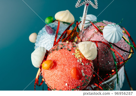 Glass with Christmas decorations on dark green background Glass with Christmas decorations on dark green background 96956287