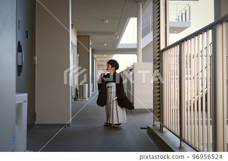 一個 5 歲的男孩在一棟公寓樓的走廊裡等電梯，去參加 Shichi-go-san 節。 96956524
