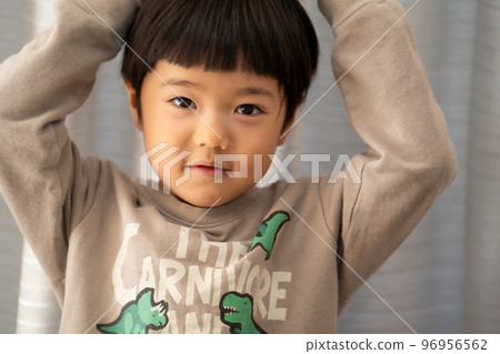 在房子的客廳裡,一個 5 歲的男孩正看著鏡頭開玩笑 在房子的客廳裡,一個 5 歲的男孩正看著鏡頭開玩笑 96956562