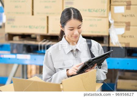 Young female worker inspecting in warehouse 96956627