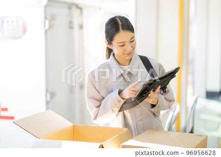 年輕女工在倉庫檢查 96956628