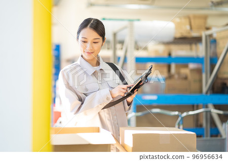 年輕女工在倉庫檢查 年輕女工在倉庫檢查 96956634