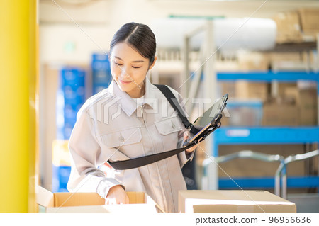 Young female worker inspecting in warehouse 96956636