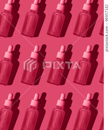 Pattern. Serum in a glass bottle with a dropper on a bright red background. Pattern. Serum in a glass bottle with a dropper on a bright red background. 96957182