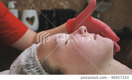 Applying powder to the client's face and massage the client's problem skin. 96957283