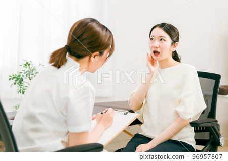 Female doctors and nurses who examine, interview, and counsel patients suffering from jaw pain at hospitals, osteopathic clinics, and chiropractic clinics 96957807