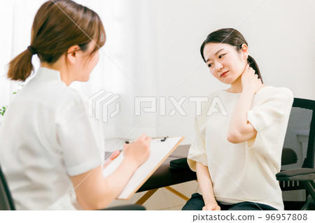 Female doctors and nurses who examine, interview, and counsel patients suffering from neck pain at hospitals, osteopathic clinics, and chiropractic clinics 96957808