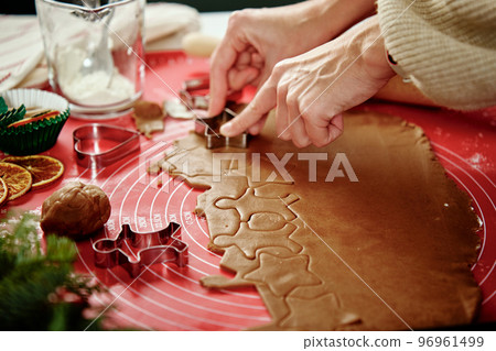 Process of woman making gingerbread cookies at home 96961499