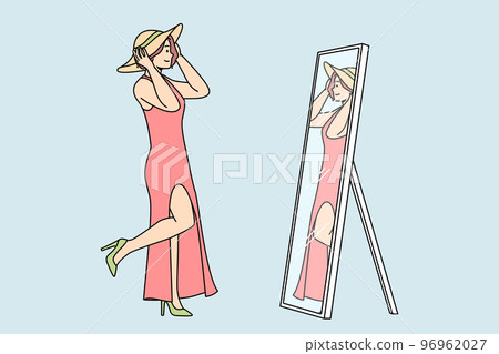 Woman in dress, shoes, tries on hat in front of mirror. Woman in dress, shoes, tries on hat in front of mirror. 96962027