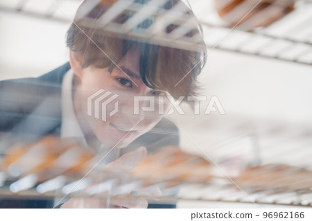 Young man buying sweets at patisserie Young man buying sweets at patisserie 96962166