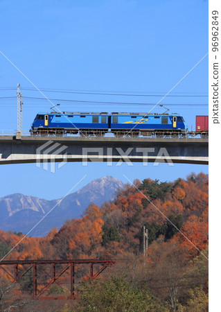 Freight train towed by EH200 crossing the Shintategawa Bridge with Yatsugatake and the Old Tategawa Bridge in the background_photographed on 11/18/2022 96962849