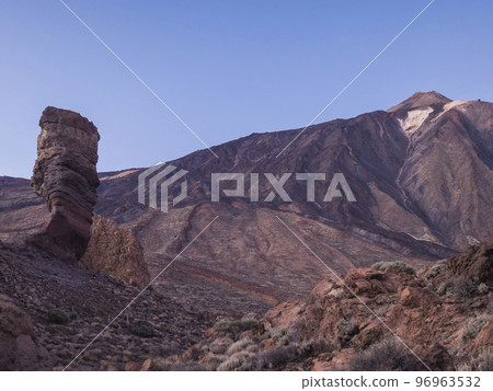 Scenic view at Roque Cinchado, volcanic rock formation and Pico del Teide volcano at El Teide national park in red sunset light colors. Tenerife Canary islands, Spain. Scenic view at Roque Cinchado, volcanic rock formation and Pico del Teide volcano at El Teide national park in red sunset light colors. Tenerife Canary islands, Spain. 96963532