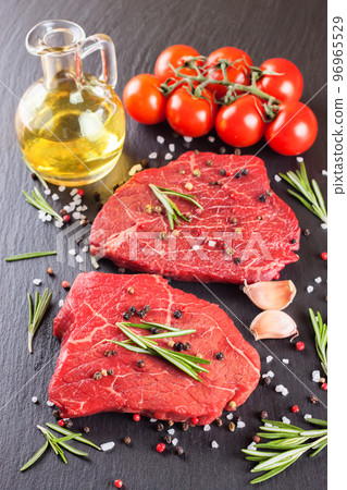 Raw steak with cooking ingridients on black slate background 96965529