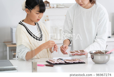 Mother and daughter making sweets Mother and daughter making sweets 96967274
