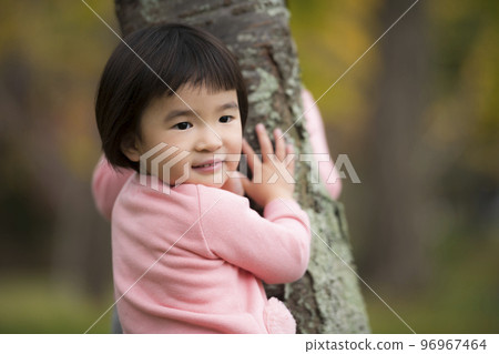 一個 3 歲的女孩在秋葉美麗的公園裡享受大自然 96967464