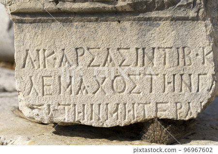 Antique greek inscriptions carved on the stone of the old ruins of an antique greek city 96967602