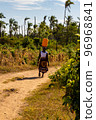 Woman carrying a water canister on her head 96968841