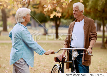 Love, bike and park with a senior couple on a date together during summer while enjoying retirement. Nature, dating and romance with a mature man and woman outdoor in a garden for bicycle bonding Love, bike and park with a senior couple on a date together during summer while enjoying retirement. Nature, dating and romance with a mature man and woman outdoor in a garden for bicycle bonding 96969752