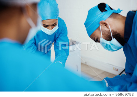 Covid, healthcare and surgery doctors in hospital for professional operation of patient. Focus, surgeons and medical people in theater with surgical face mask for protection and hygiene. 96969798