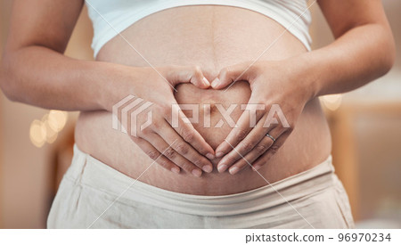 Woman, hands or heart shape on pregnant stomach in house, home living room or prenatal care clinic. Zoom, pregnancy or mother touching belly in love, care or trust of baby health, support or security Woman, hands or heart shape on pregnant stomach in house, home living room or prenatal care clinic. Zoom, pregnancy or mother touching belly in love, care or trust of baby health, support or security 96970234