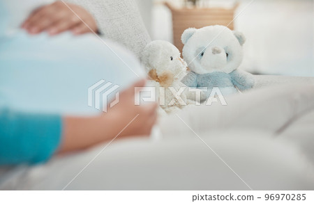 Mother, stomach and teddy bear in the background while relaxing on the sofa at home. Pregnancy, maternity and female rest in her house with toys while preparing for parenthood and motherhood 96970285