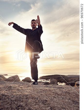 Man, tai chi and meditation while calm, mindfulness and wellness for mindfulness, balance and relax at the beach. Male meditate, training and spiritual faith outdoor at ocean during sunset in summer 96970672